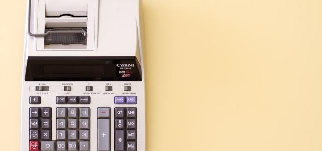 Ten key accounting calculator on a soft yellow desk